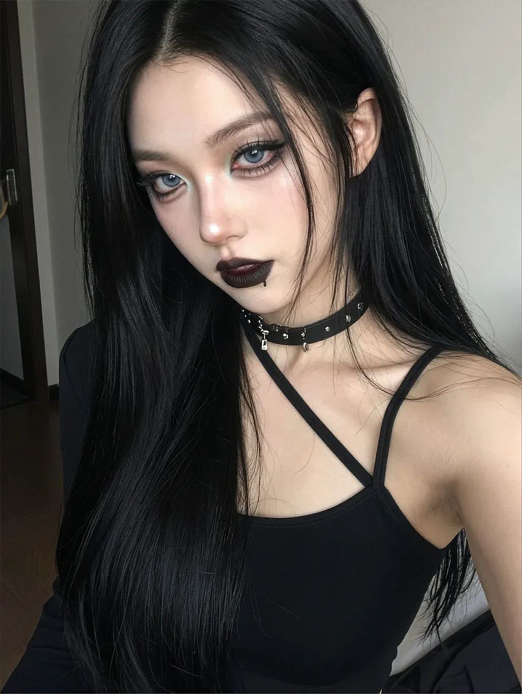 Profile portrait of a fictional AI character with long black hair, dark lipstick and a choker, in a black camisole